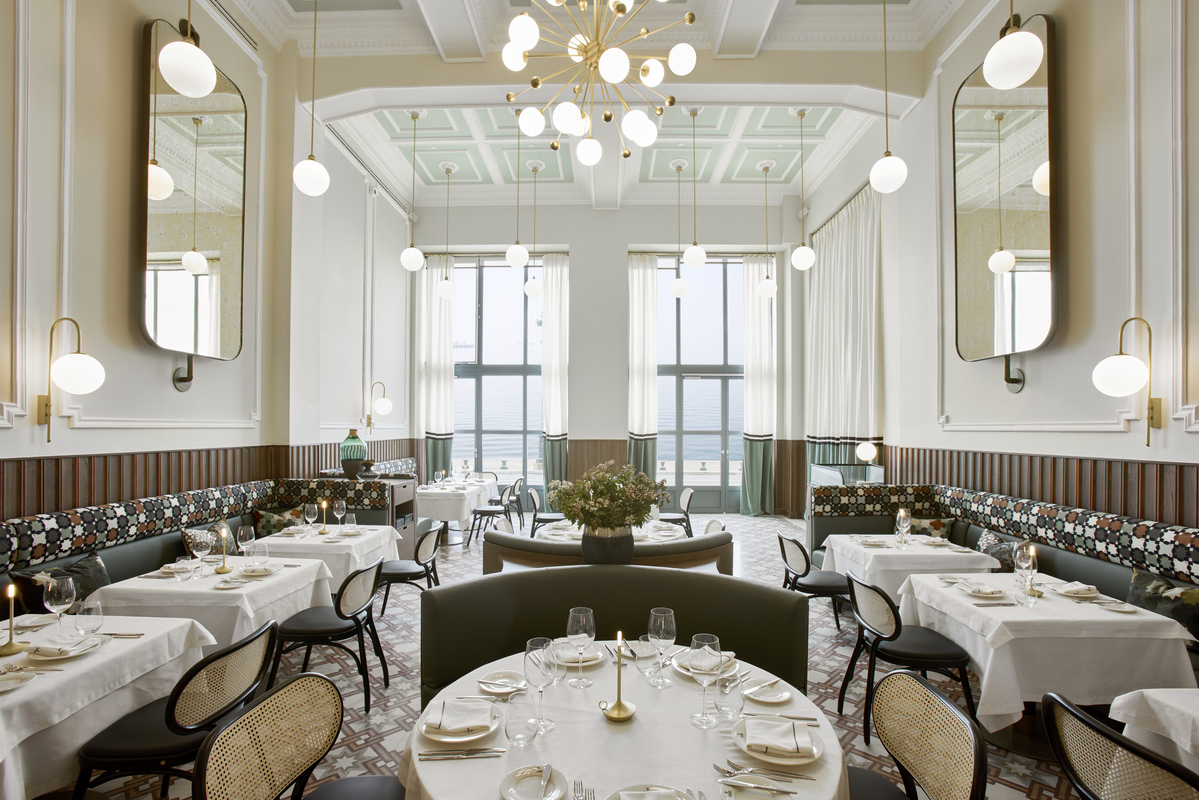 
Bright restaurant dining hall with sea view. elegant round tables and chandeliers at ON Residence Hotel