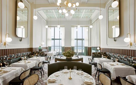 Bright restaurant dining hall with sea view. elegant round tables and chandeliers at ON Residence Hotel