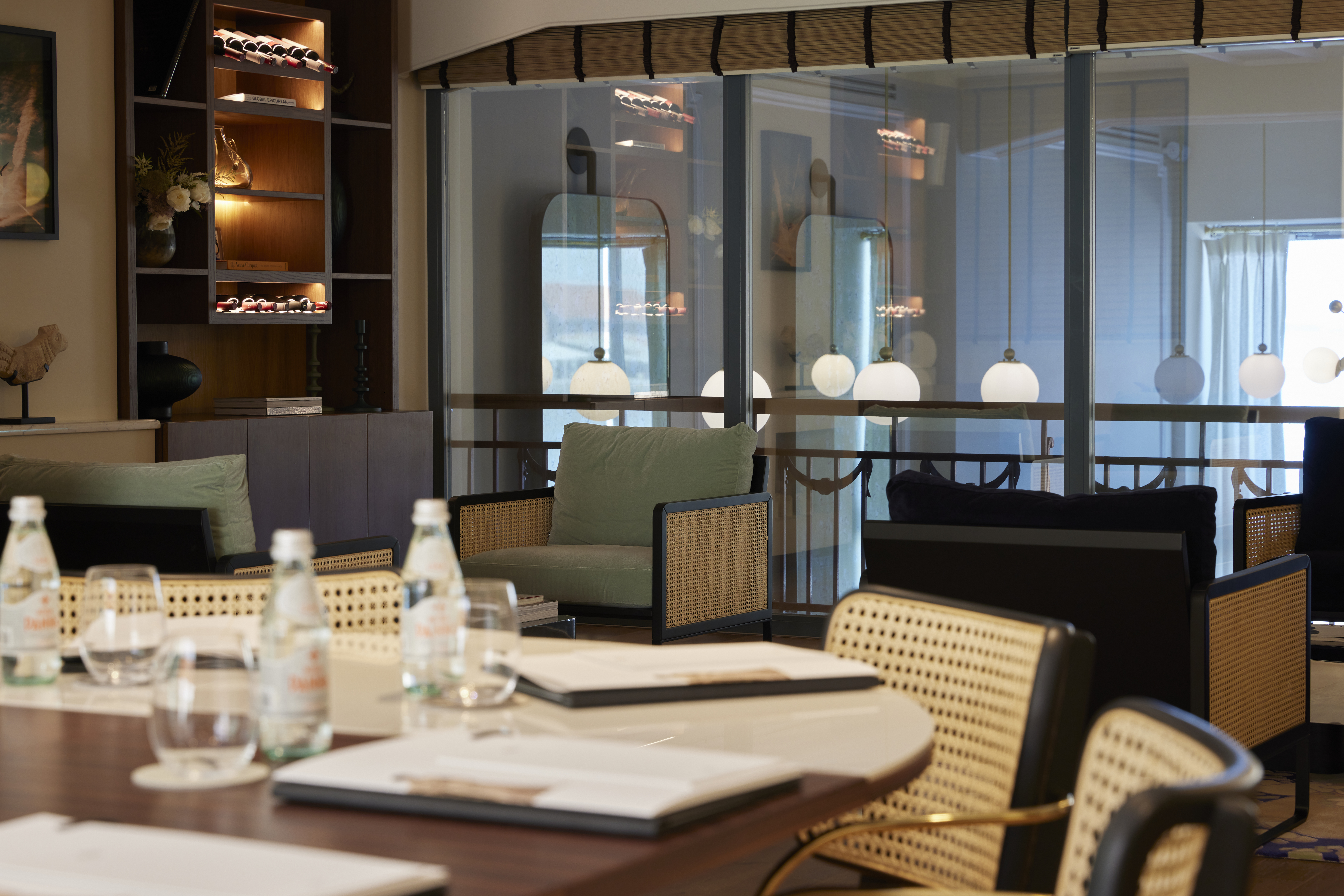 
Stylish meeting room with wooden table, natural light, rattan chairs and lounge seating at ON Residence