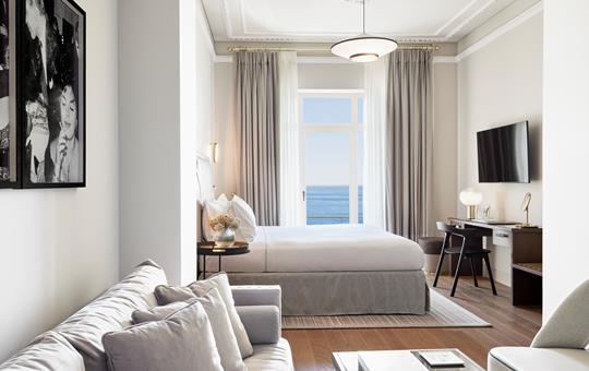 Balcony sea view from the elegant Méditerranée suite with king bed, sofa and workspace at ON Residence Hotel