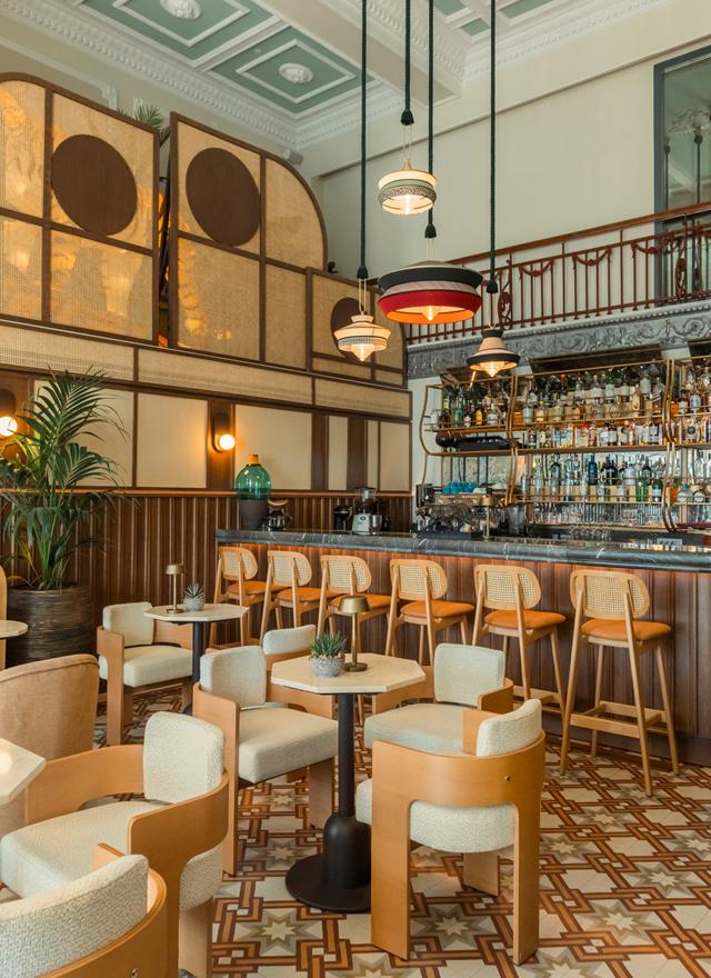Stylish bar area with patterned flooring, retro pendant lights, and wooden counter seating at Tiger Loop Bar