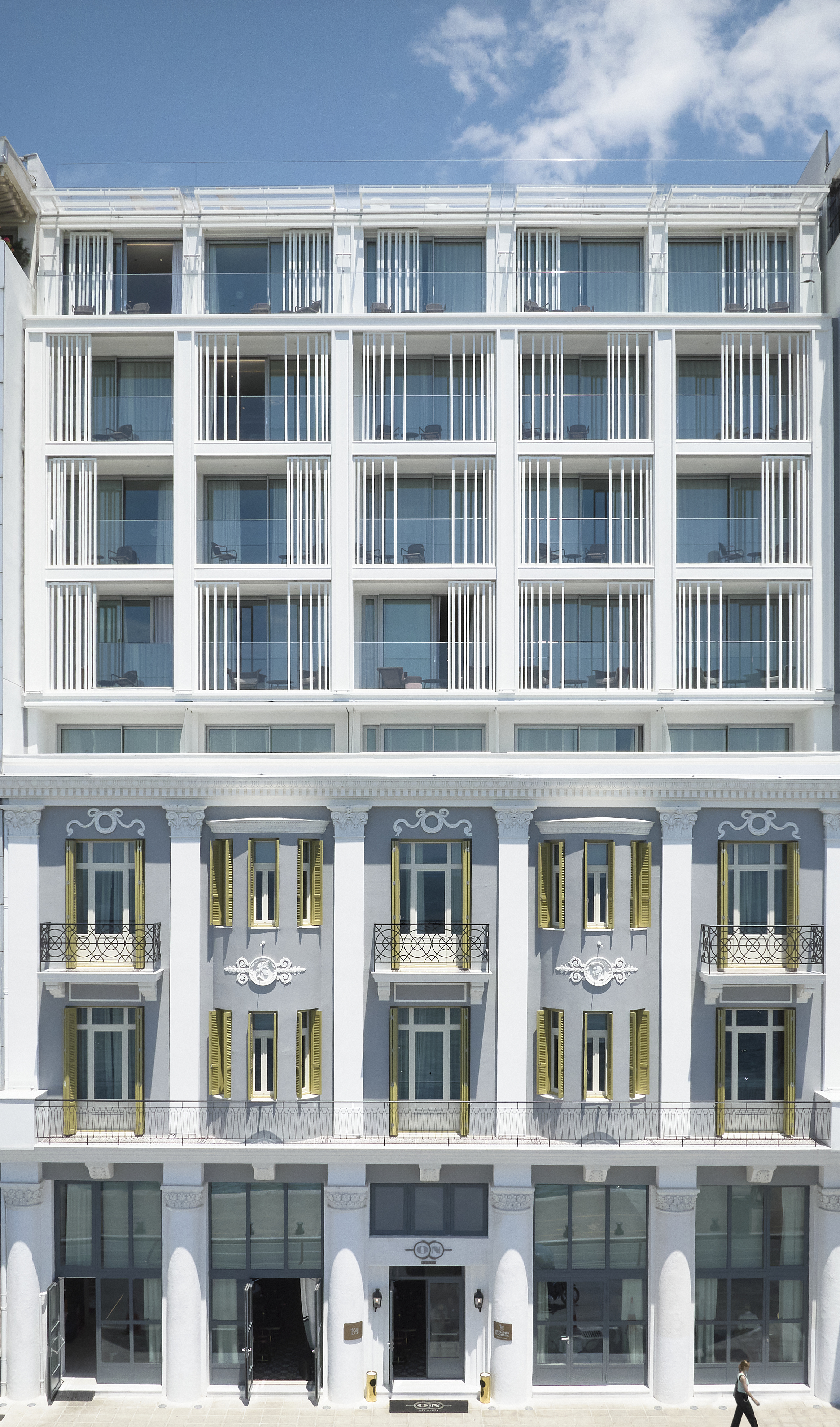 
ON Residence Hotel exterior with neoclassical facade and modern upper floors under blue sky