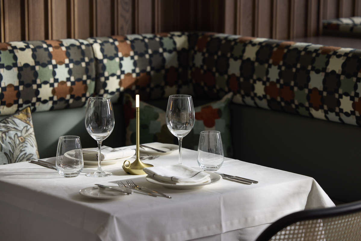 
Elegant restaurant table with wine glasses, golden candle and white linen at ON Residence Hotel