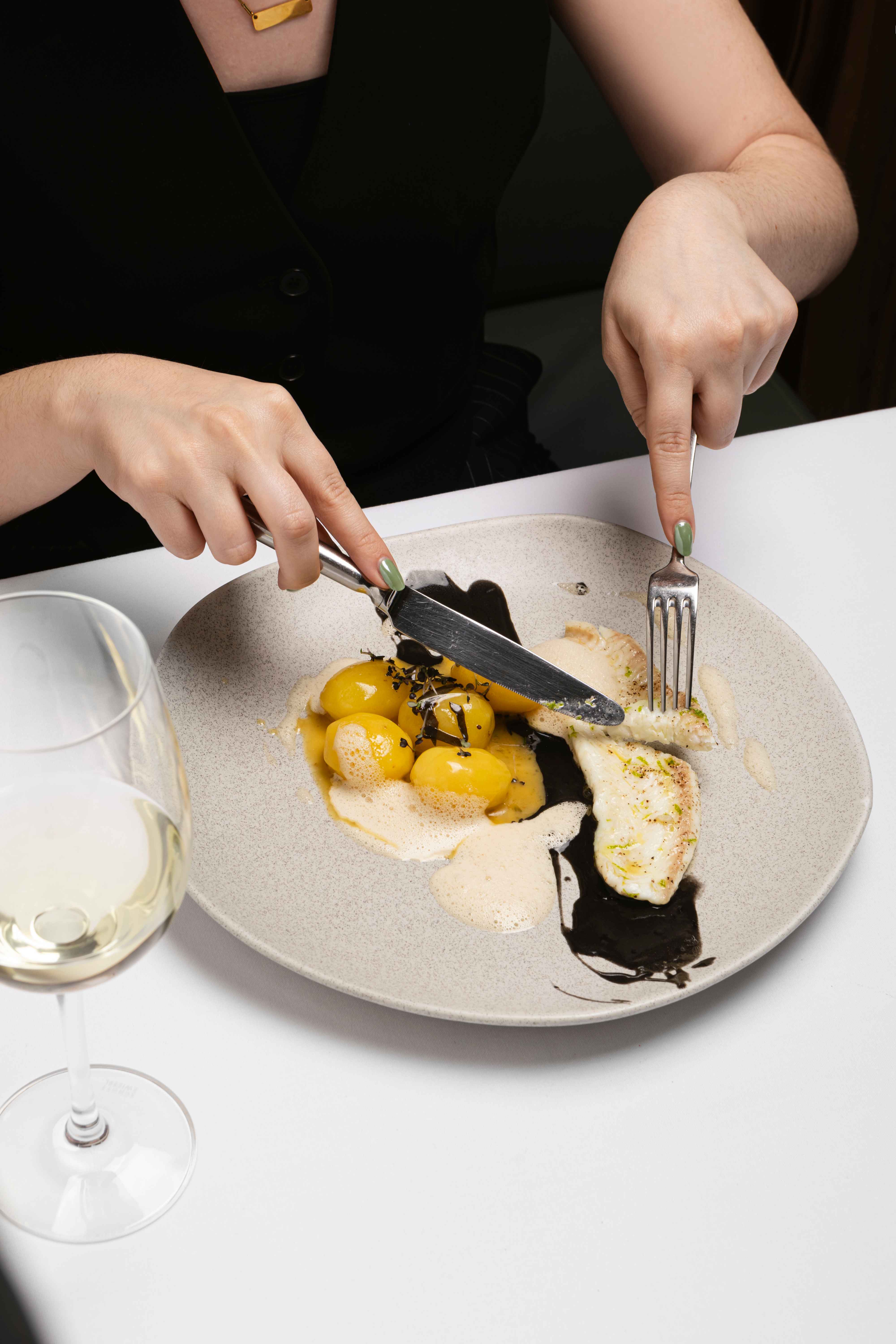 
Fine dining dish of sole meunière with baby potatoes, foam sauce and squid ink at Olympos Naousa restaurant