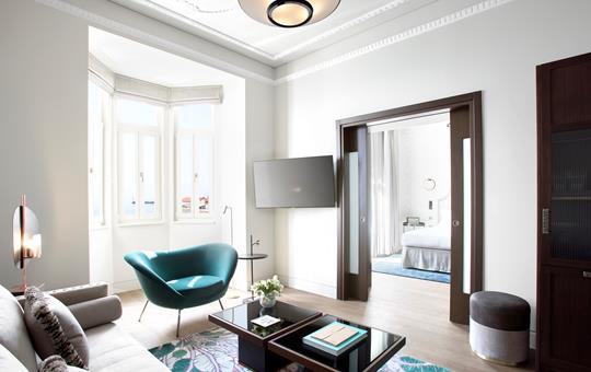 Bright living room in Méditerranée Grand suite with teal armchair, modern decor and sea view at ON Residence Hotel