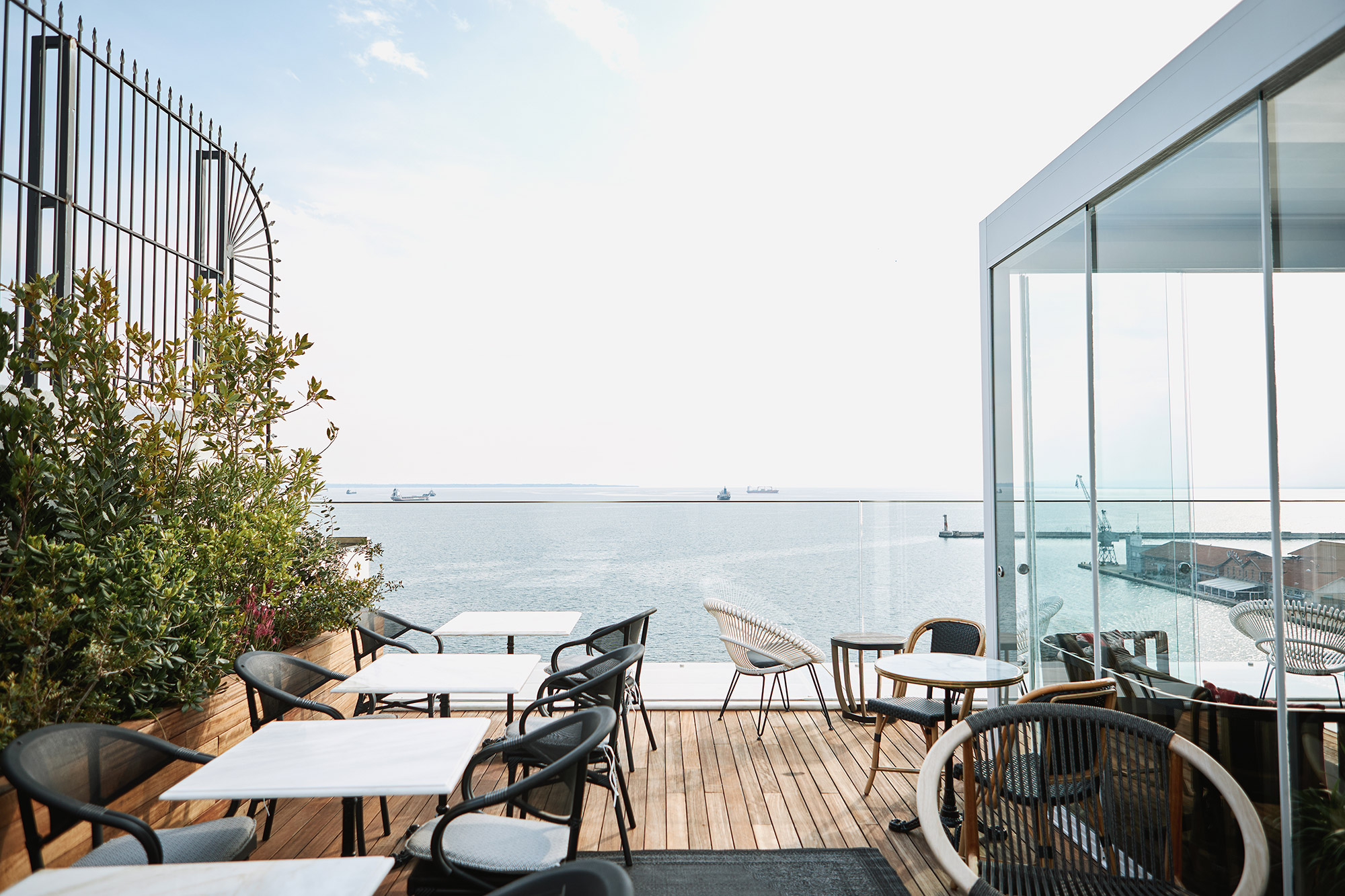 
Stylish ON Residence rooftop opening with elegant seating, wooden deck and panoramic sea view