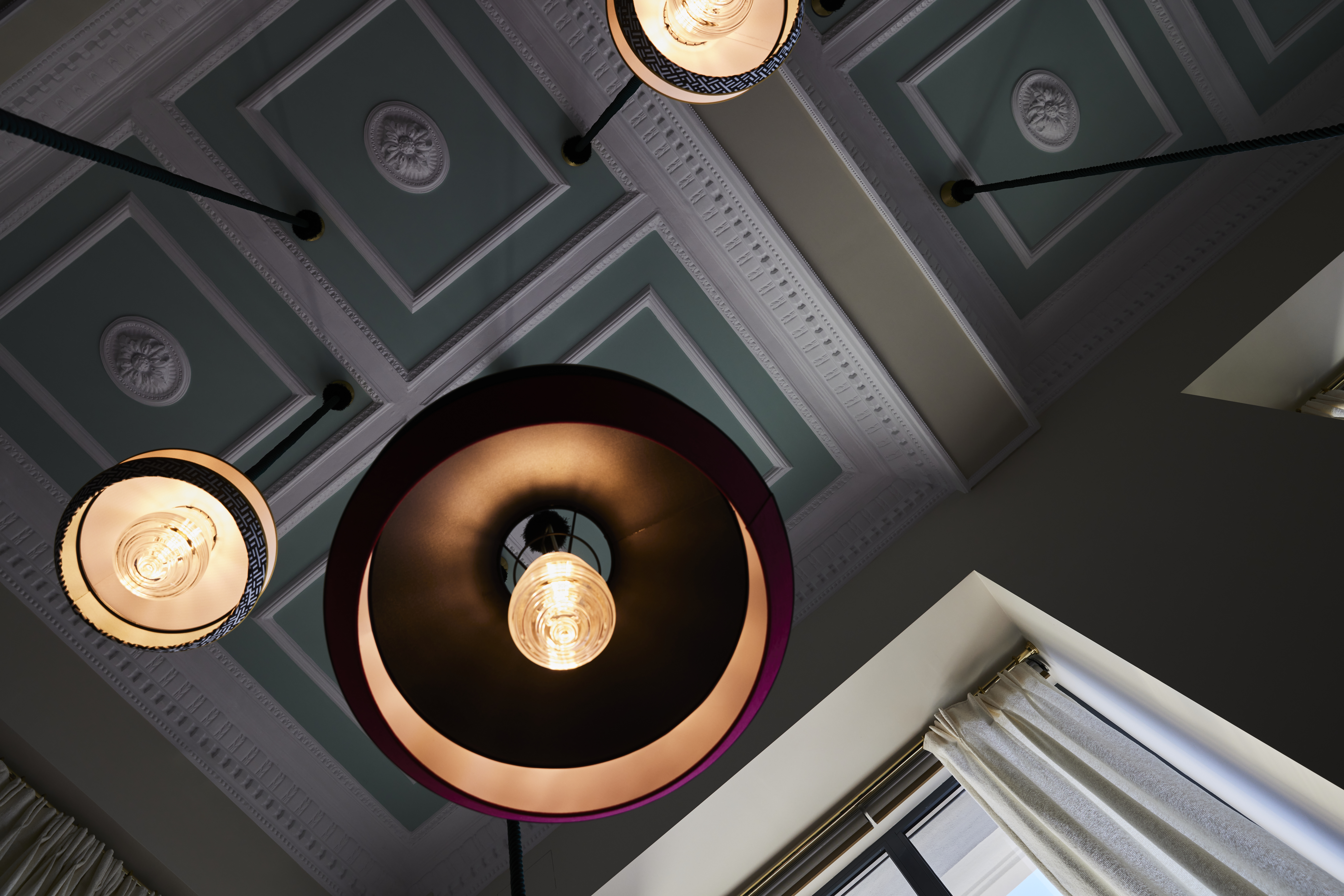 
Tiger Loop Bar ceiling with ornate plaster details and vintage pendant lights at ON Residence